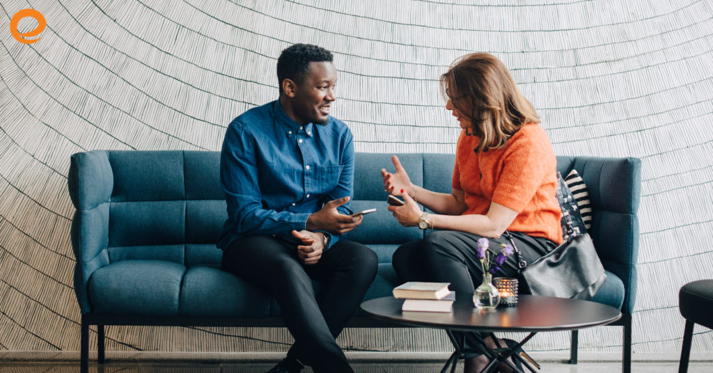 Man and woman sitting on a couch talking