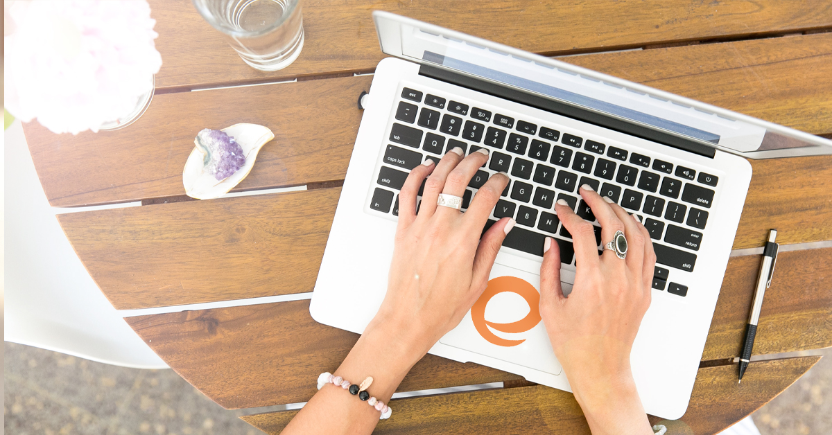 a womans hands typing on a computer