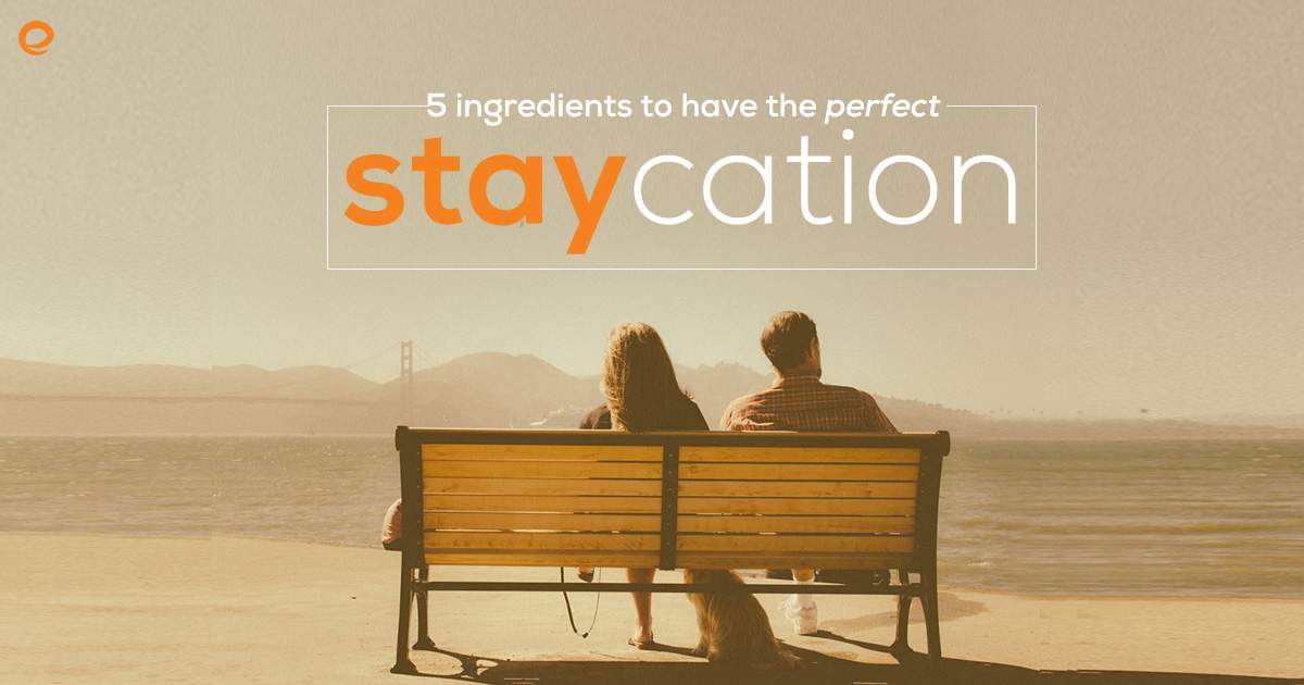 couple sitting on a park bench looking at the water