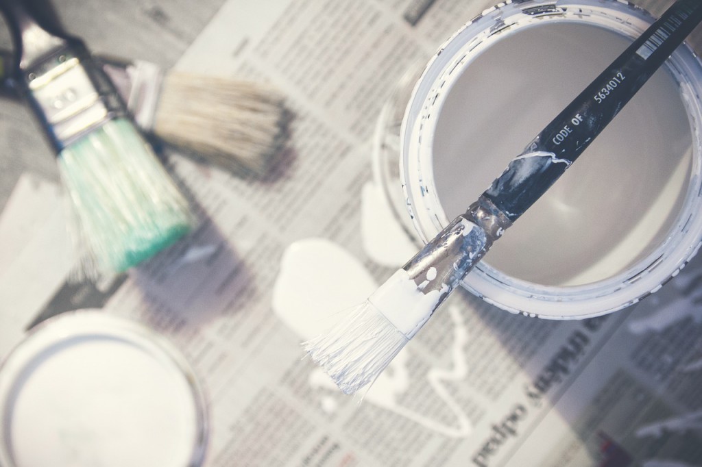 Improvement White Paint can and brush on newspaper